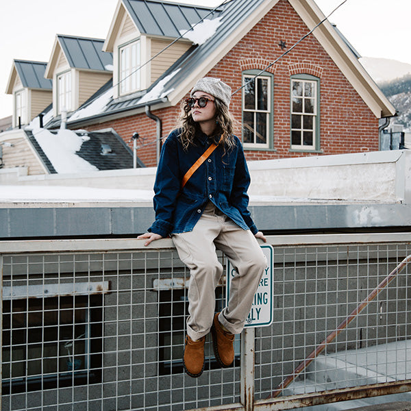 December Favorite Fits 2023 : Model wearing a dark indigo Cottle jacket, ecru bucket hat, beige work pants, orange crossbody bag, and brown clogs.