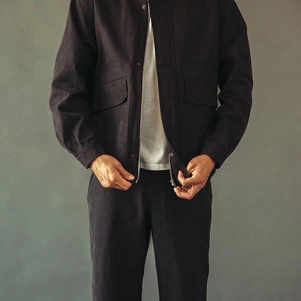 Model wearing a black [arla. pants and tan lea