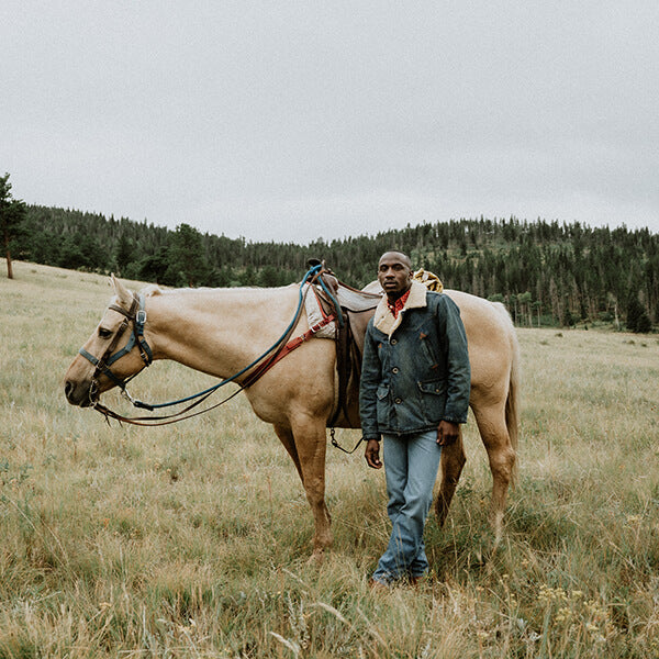 Man in RRL in a field with a horse