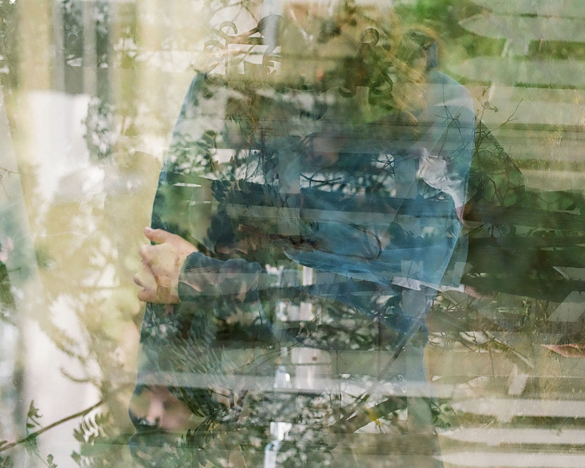 grainy film photo of a woman wearing a blue Monostereo hoodie