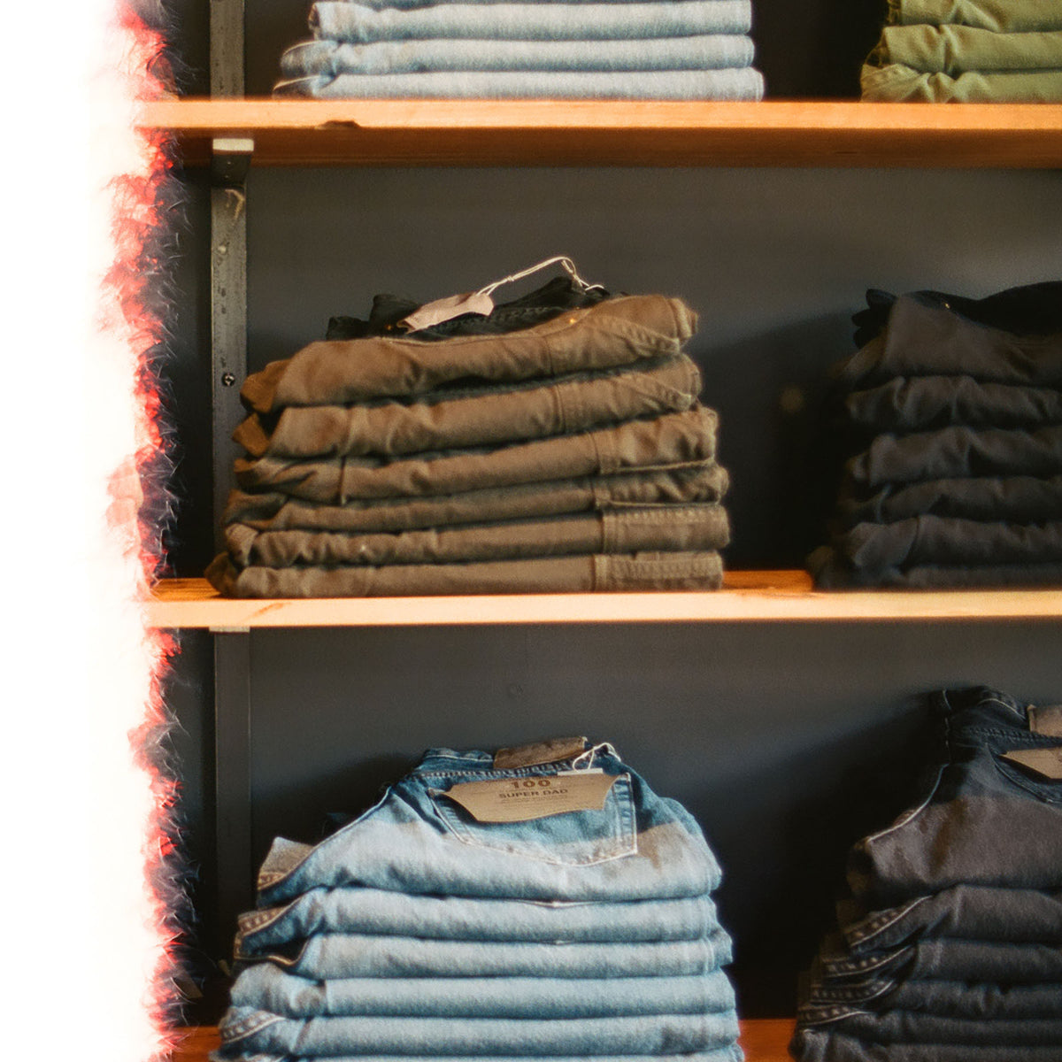 grainy film photo of shelves showing stacks of orslow denim and fatigues